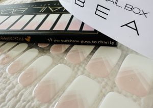 A pink ombre with geometric lines in white Semi Cured Gel Nail Sticker Kit displayed here with Bean LED lamp and Nail Box package sold by Nail Box